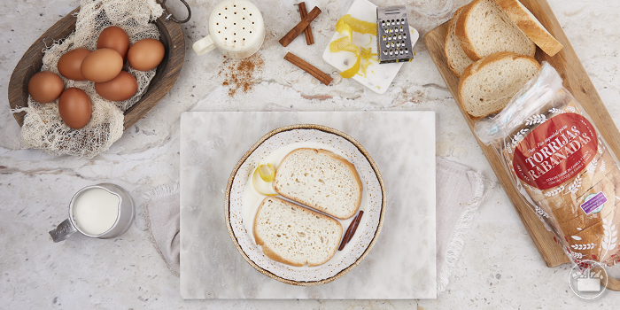 Coloque as fatias de pão num tabuleiro, regue com o leite e deixe repousar durante 5 minutos para que fiquem bem encharcadas.