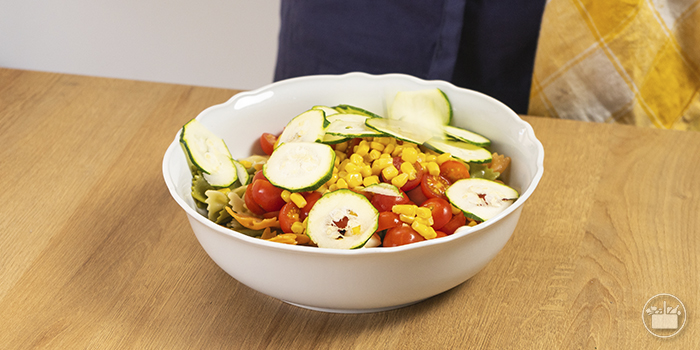 Montar a salada com todos os elementos: a massa, a mozzarella, o milho, os tomates cherry e a curgete. 