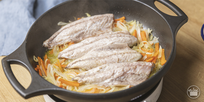 Colocar os lombos de cavala, com a pele para baixo, em cima da cebola e da cenoura e deixar cozinhar lentamente durante cerca de 10 minutos, até que o peixe esteja no ponto.